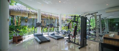A gym with treadmills, elliptical machines, and weightlifting equipment.