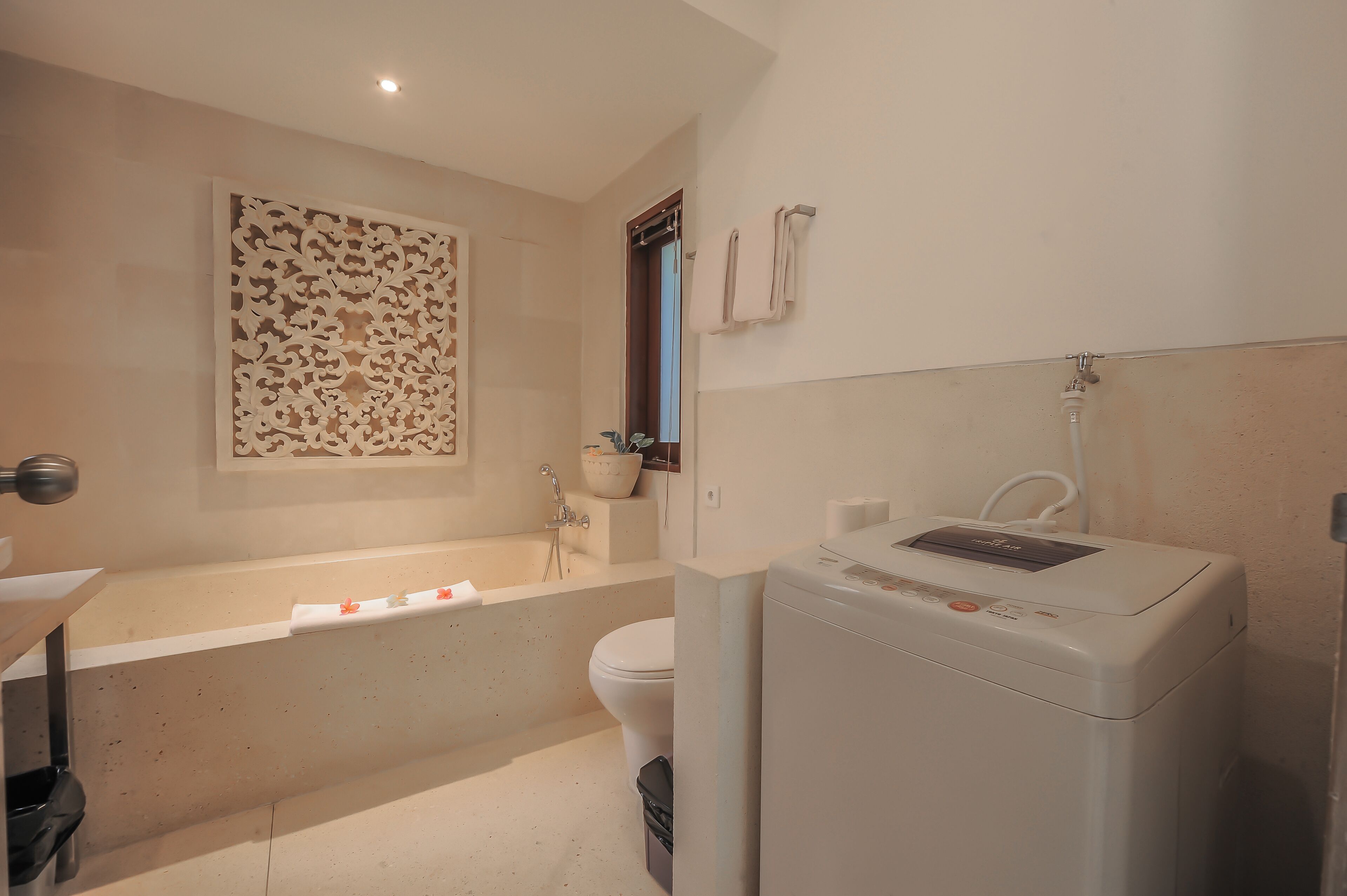 Ein Badezimmer mit Badewanne, Toilette und Waschmaschine.