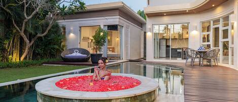 Une maison moderne dotée d’une piscine, d’un coin repas et d’un jardin bien entretenu.