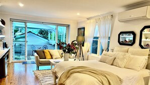 A bedroom with a large bed, a desk, and a view of the outside. - Studio minutes from Waterfront walks, close to Pasadenas, cafes, restaurants  (Bayview)