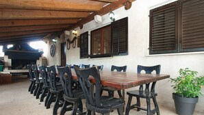 A dining area with a long wooden table and black chairs, a potted plant, and a rustic ceiling. - Apartment 2010/28524 (Istria - Stinjan), 1250m from the beach (Stinjan)