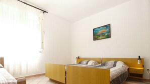 A bedroom with a wooden bed, a nightstand, a lamp, and a painting on the wall. - Apartment 2010/28524 (Istria - Stinjan), 1250m from the beach (Stinjan)