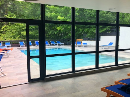 Una piscina al aire libre de temporada, sillones reclinables de piscina