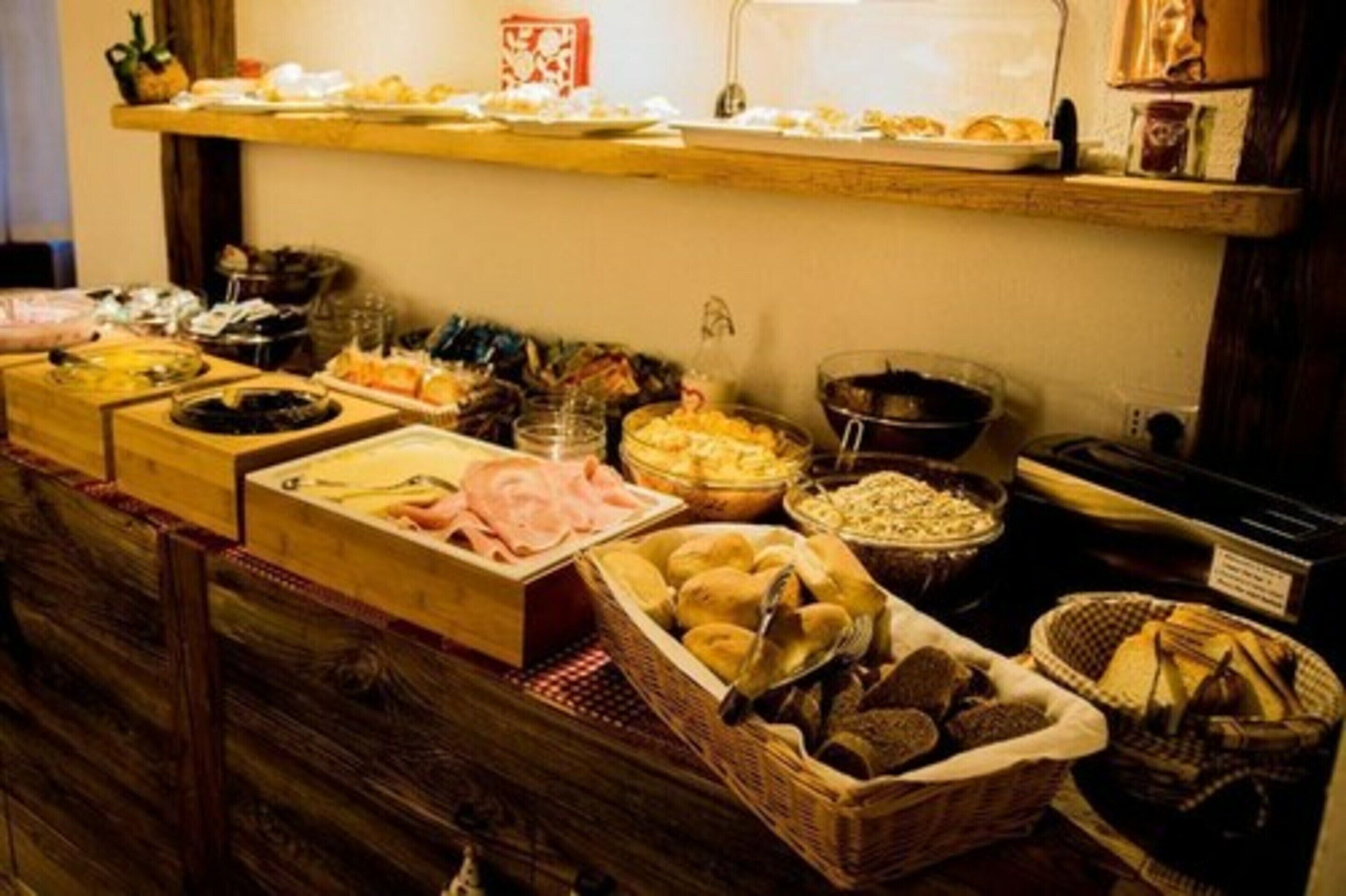 A buffet with various food items including meats, breads, and pastries.
