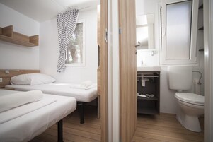 Un baño moderno y limpio con inodoro, lavamanos y zona de ducha.