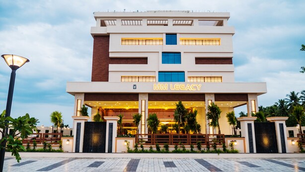 A modern hotel with a prominent entrance, multiple floors, and a well-lit facade.