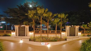 A gated entrance with a 'No Entry' sign, palm trees, and a tiled walkway.