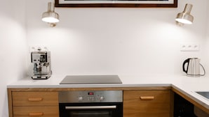 A modern kitchen with a Bosch oven, a coffee machine, and a framed lunar phases artwork above the counter. - Warsaw Concierge Saska Studio (Warsaw)