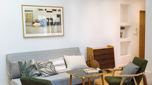A living room with a sofa, two armchairs, a coffee table, a framed picture on the wall, and a wooden cabinet. - Warsaw Concierge Saska Studio (Warsaw)