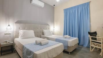 Habitación triple, vistas a la ciudad | Caja fuerte, tabla de planchar con plancha, wifi gratis y ropa de cama