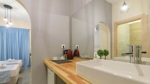 A modern bathroom with a large white sink, a mirror, and a wooden countertop.