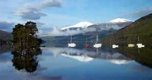 Experience serene lakeside tranquility with breathtaking views of the surrounding mountains and lush greenery.