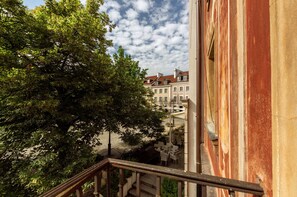 Stairs lead to an outdoor area with a view of traditional European-style buildings featuring pitched roofs and symmetrical facades.