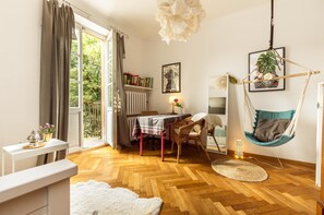 Relax in this inviting room with a dining table, comfortable seating, and a view of lush greenery.