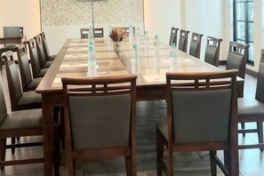 A conference room with a long table, chairs, and water bottles. - Olive Tree Hotel Pattaya (Sattahip)
