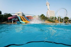 A water park with a large pool, a water slide, and a roller coaster. - Olive Tree Hotel Pattaya (Sattahip)