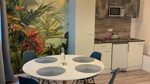 Una cocina moderna con armarios blancos, un microondas y un refrigerador pequeño.
