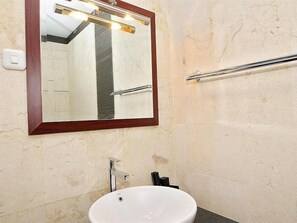 A bathroom with a white sink, a mirror with a wooden frame, and a towel rack. - Dago Heuvel Resort (Cimenyan)