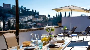 Mesa al aire libre con vista a un paisaje urbano, que incluye una estructura similar a un castillo.
