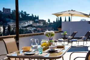 Mesa al aire libre con vista a un paisaje urbano, que incluye una estructura similar a un castillo.