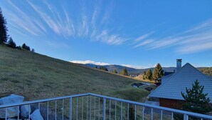 A hillside with a house and a metal railing.