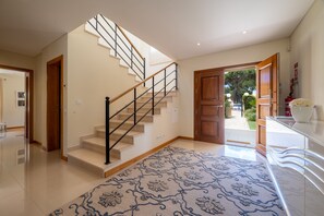 A modern interior with a staircase, a patterned rug, and a view of the outdoors. - VILLA SIBLING 2. Golf resort villa with 4 bedrooms and private pool,  (Quarteira)