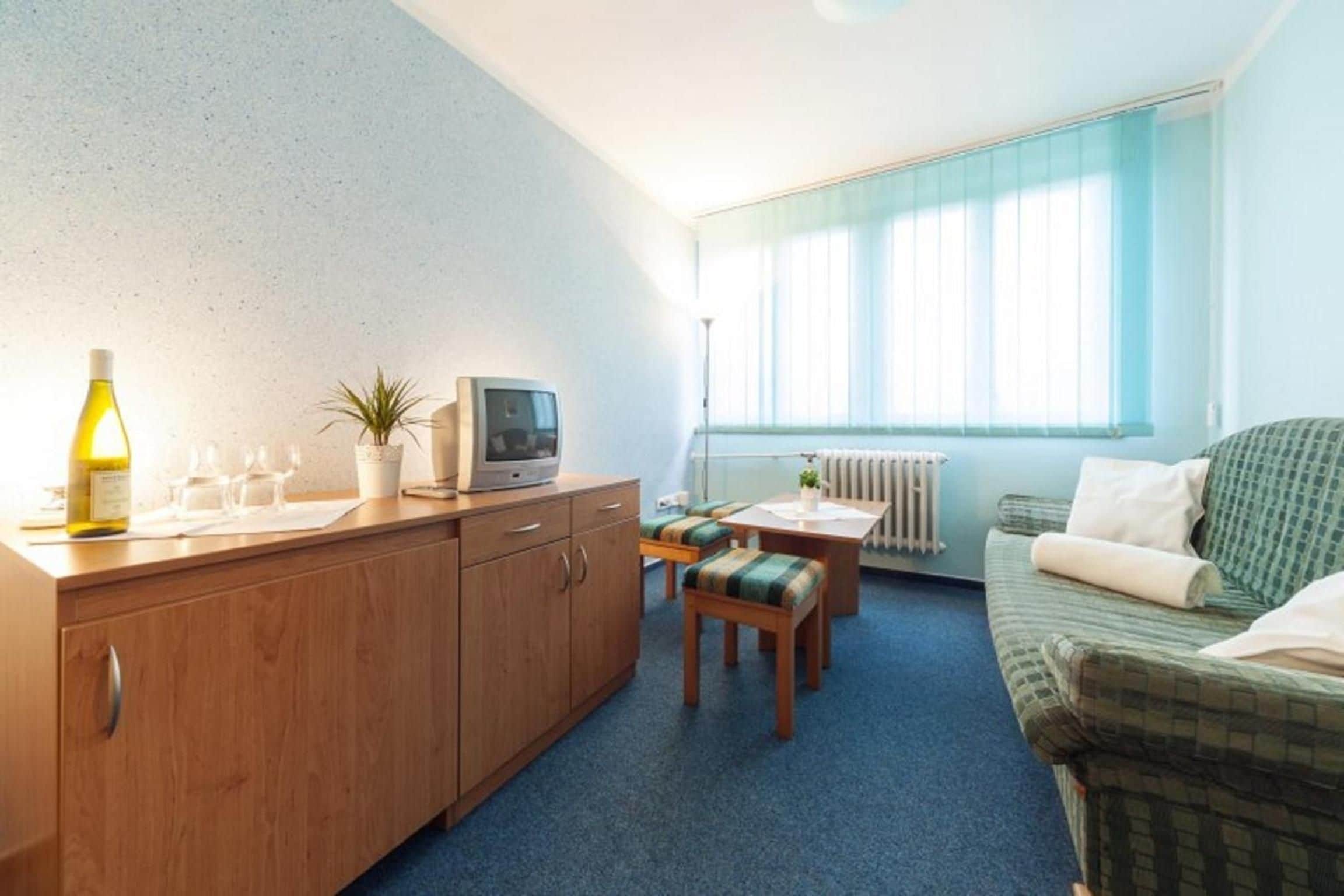 A compact living space with a kitchenette, a dining area, and a sofa.