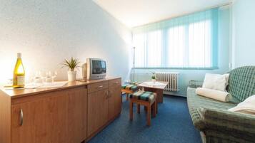 A compact living space with a kitchenette, a dining area, and a sofa.
