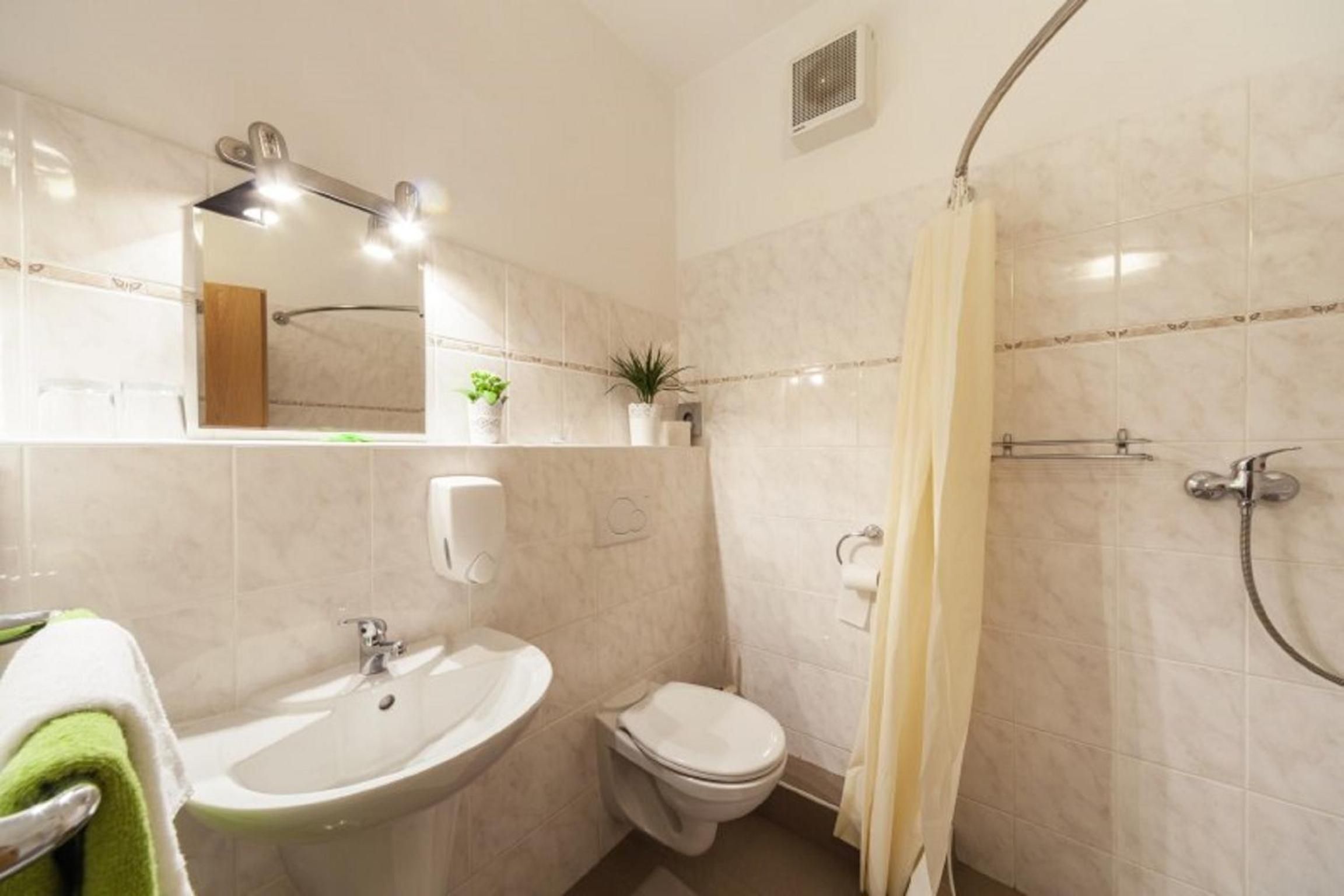 A bathroom with a sink, toilet, and shower.
