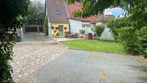 Una casa con techo inclinado, garaje y césped bien cuidado.