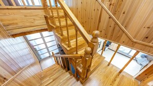 Un intérieur en bois avec un escalier en colimaçon, des murs en bois et une fenêtre.