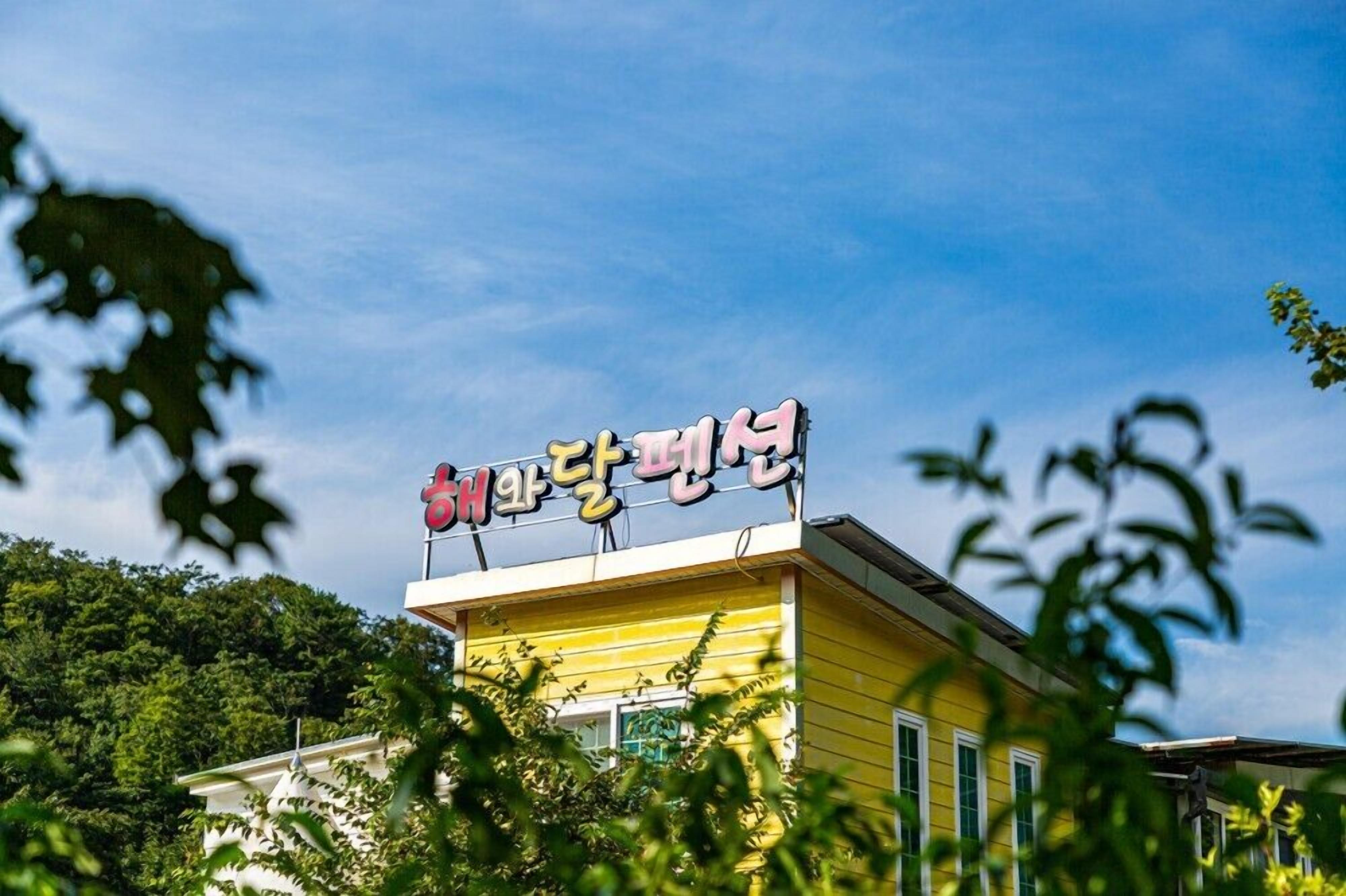 A yellow building with a sign in a foreign language.