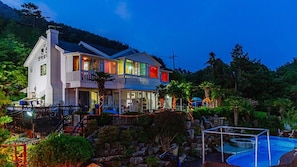 A two-story house with a balcony, a swimming pool, and a garden. - Santamonica Pension (Geoje)