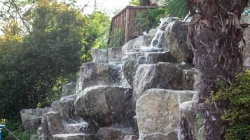 Una cascada que se precipita sobre grandes rocas en un entorno natural.