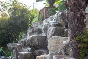 A waterfall cascading over large rocks in a natural setting.