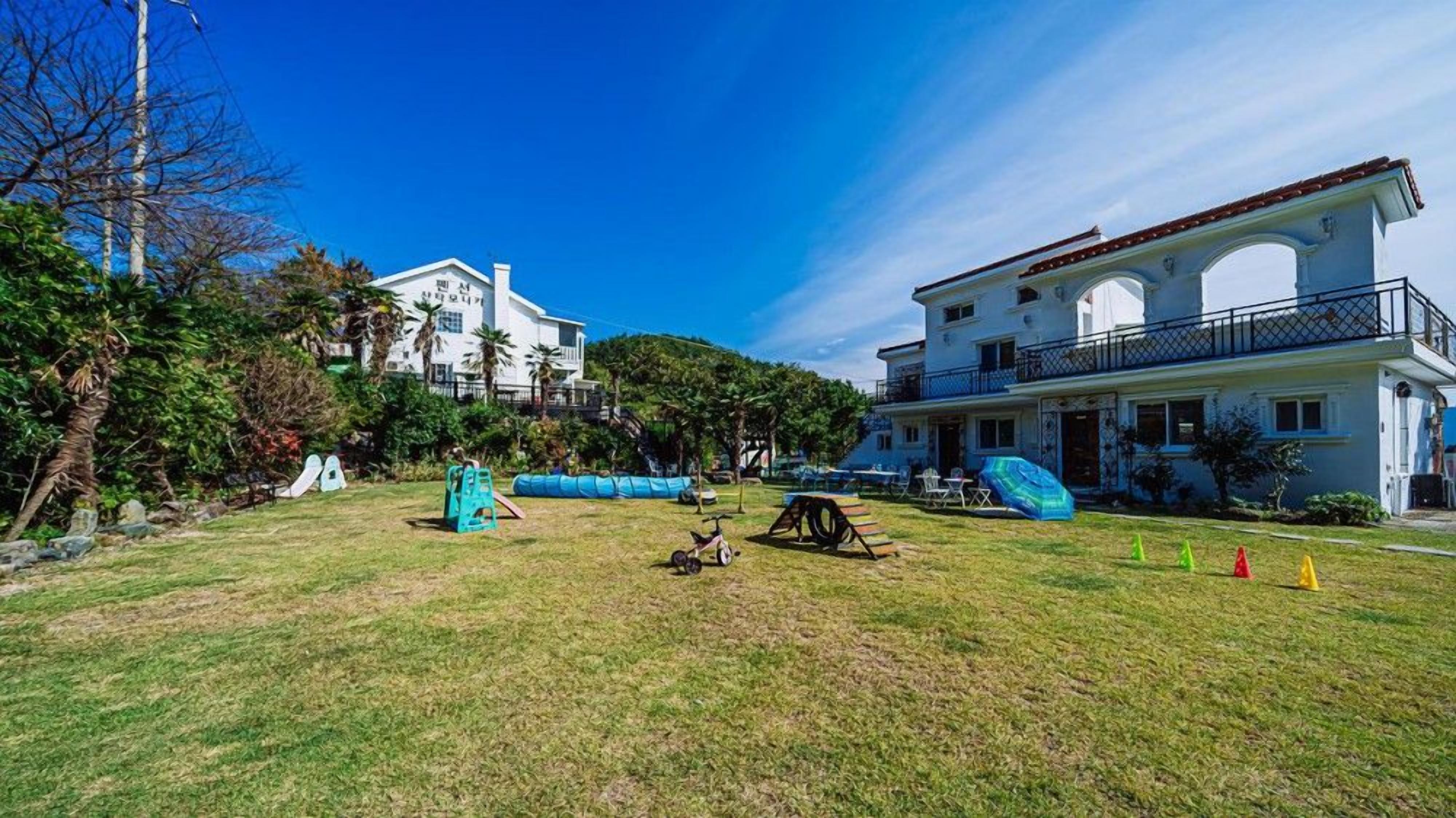 Zona residencial con un edificio grande y blanco que tiene un balcón y ventanas de arco.