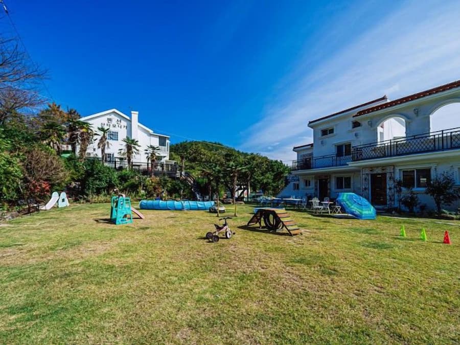 Zona residencial con un edificio grande y blanco que tiene un balcón y ventanas de arco.