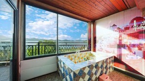 A bathroom with a large window, a bathtub, and a view of greenery and mountains. - Santamonica Pension (Geoje)