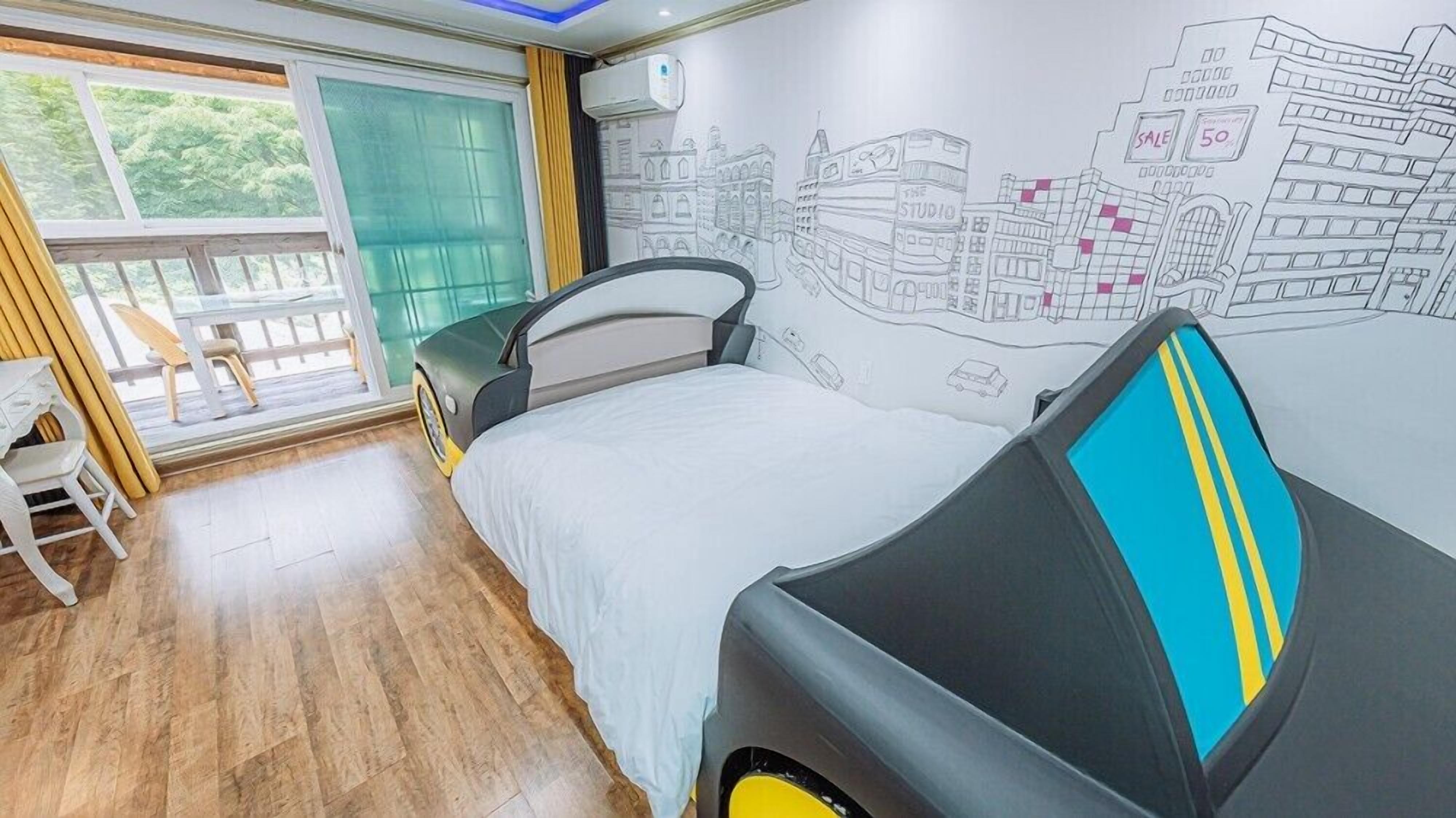 A bedroom with a bed, a chair, a window, and a wall mural.
