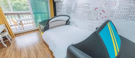 A bedroom with a bed, a chair, a window, and a wall mural.