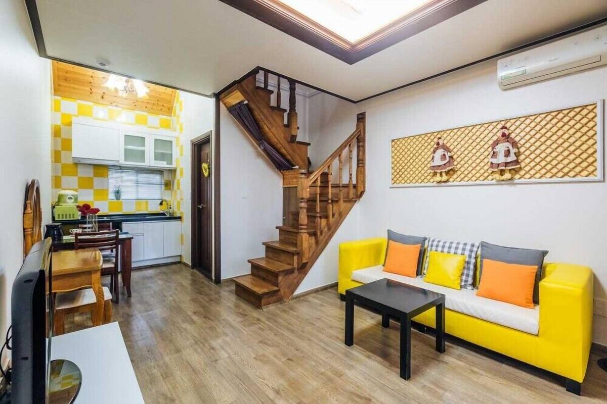 A compact living space with a kitchen, dining area, and a staircase.