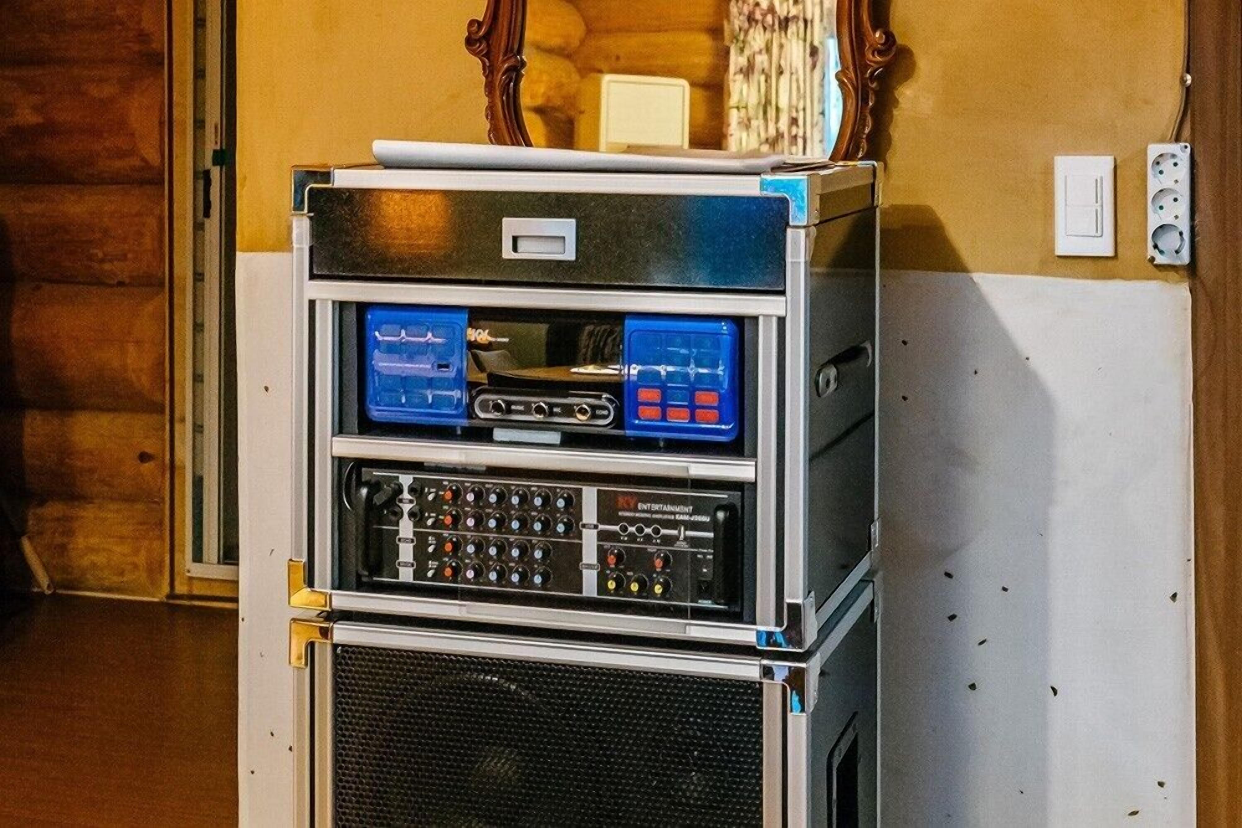 Equipo de audio con múltiples puertos de entrada y salida, un panel de control y una rejilla para el altavoz.