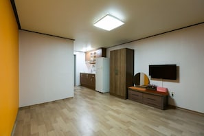 A modern kitchen with wooden cabinets, a refrigerator, and a built-in oven. - Gatnaeum Pension (Geoje)