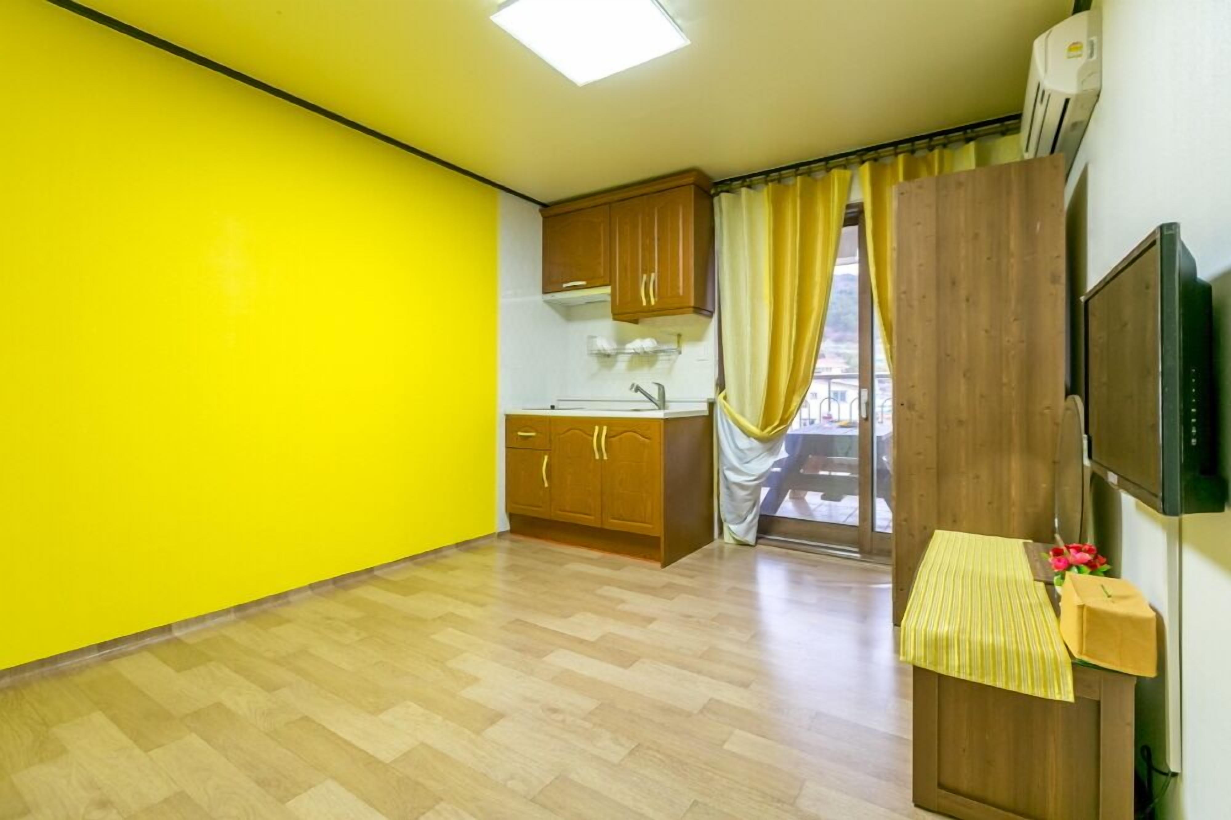 A compact kitchen with wooden cabinets, a sink, and a microwave.
