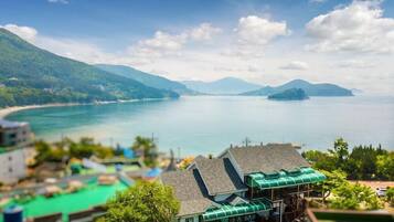 A coastal hotel with a view of the sea and mountains.