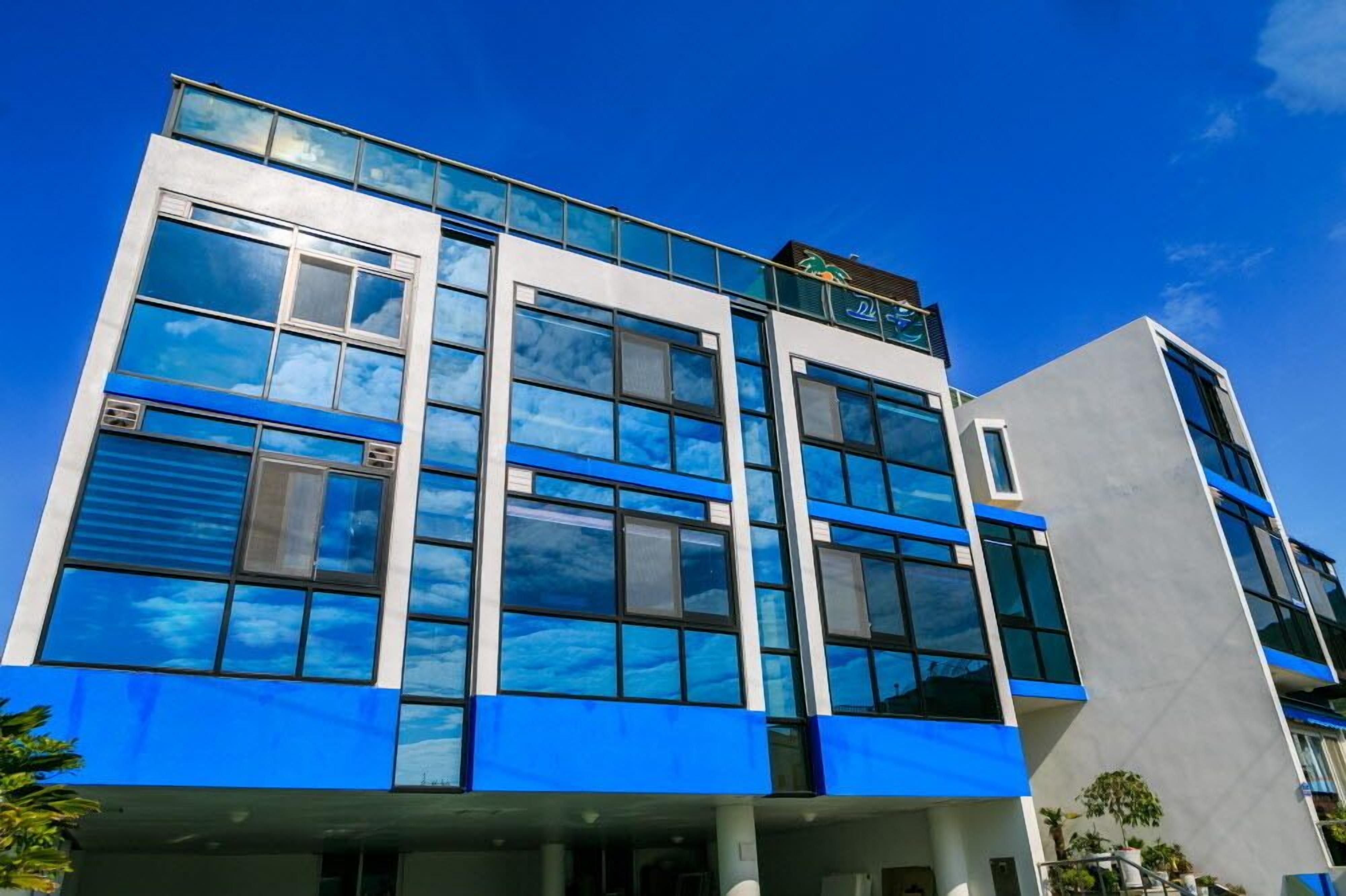 A modern building with large windows and a blue facade.