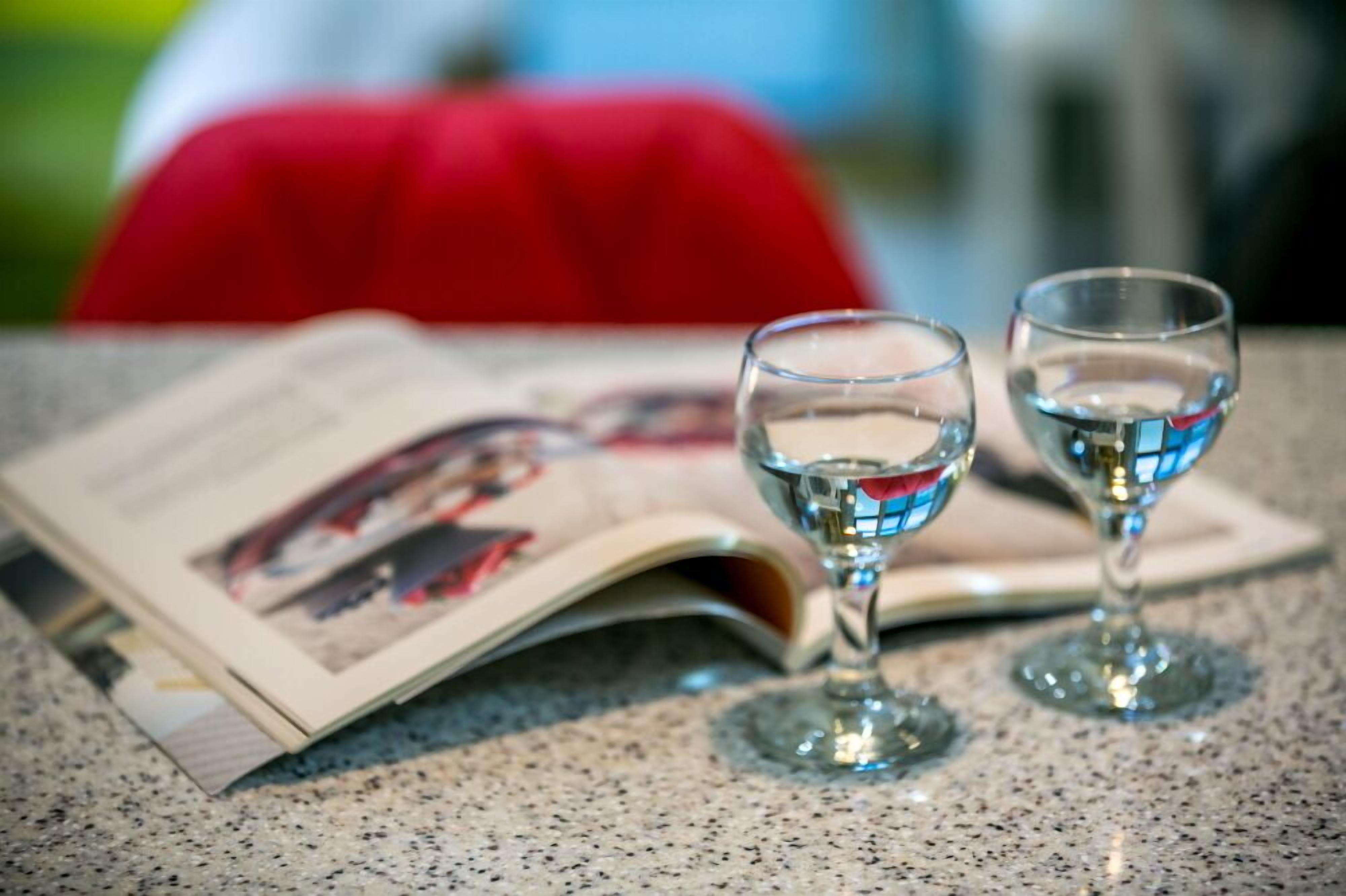Een krant op een tafel met twee glaasjes water.