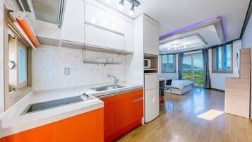 A modern kitchen with a large window, a built-in microwave, and a dining area with a view.