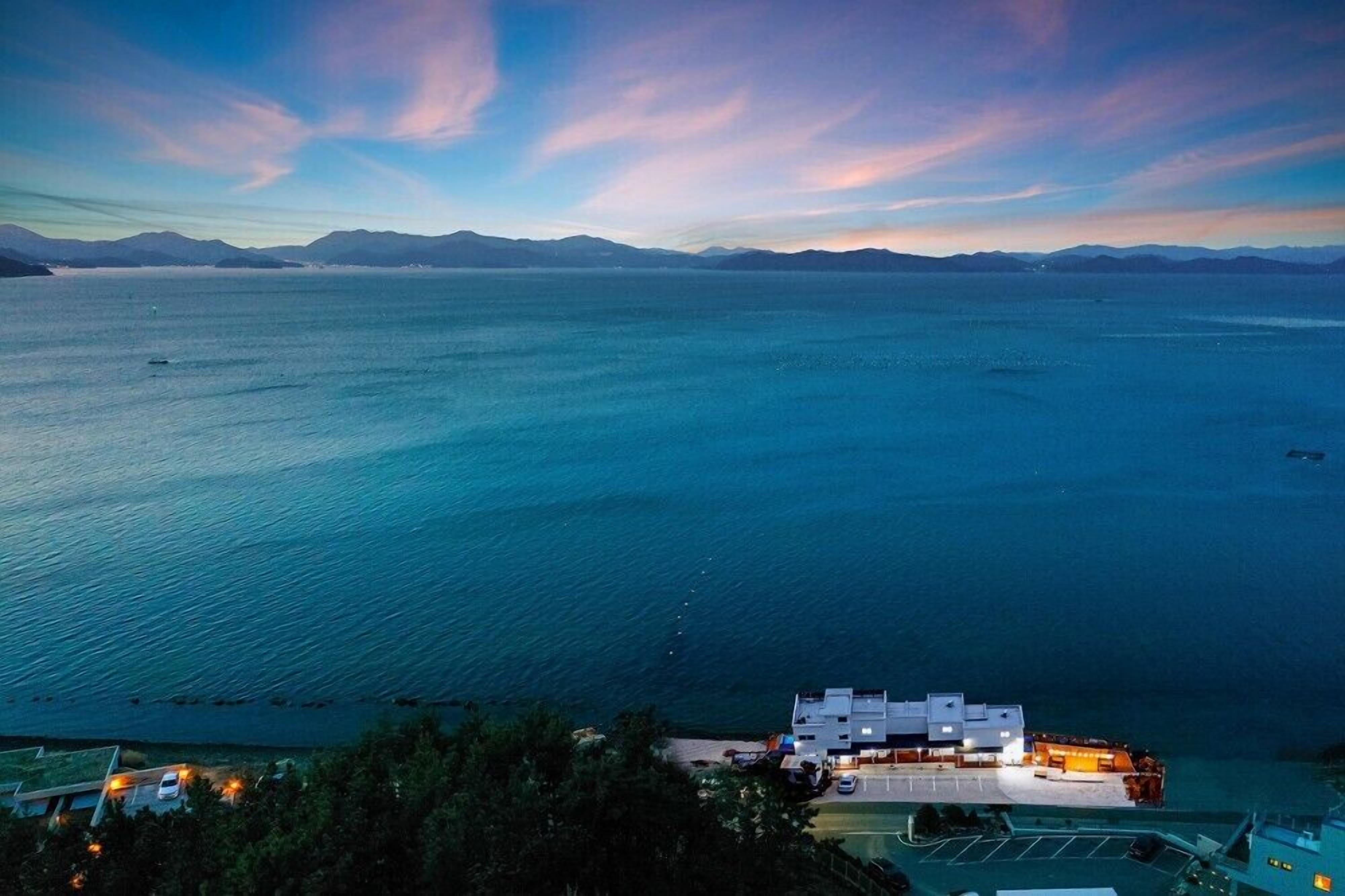Ett hotell vid kusten med utsikt över havet och bergen.