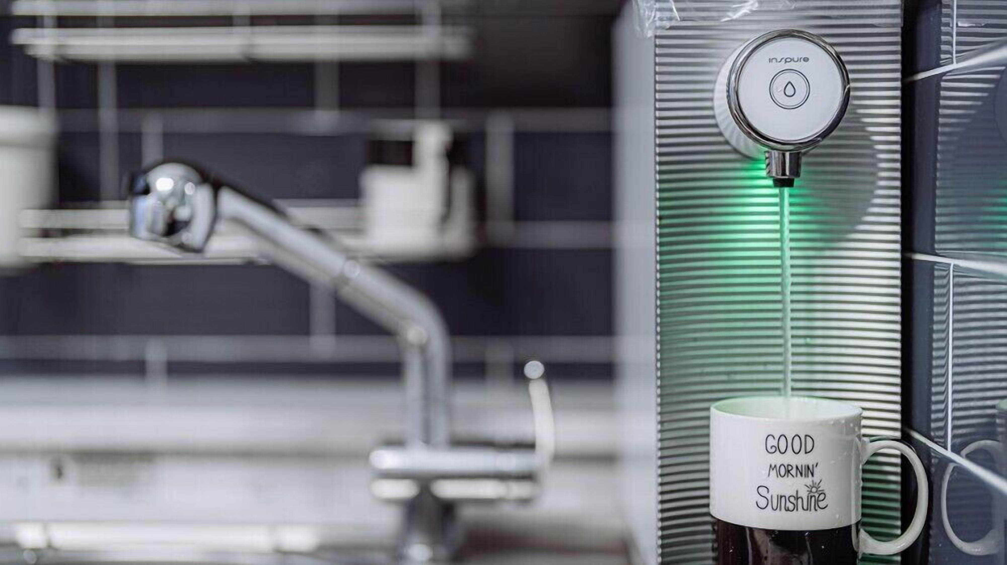 A modern bathroom with a shower, a water heater, and a mug with 'Good Morning Sunshine' written on it.